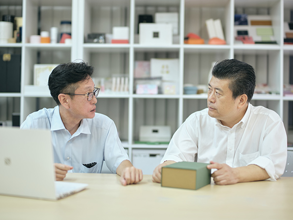 プラシーズ本社と中国工場をつなぐのが、営業部長の阿部さんと、中国製造部門の鐘（しょう）さん